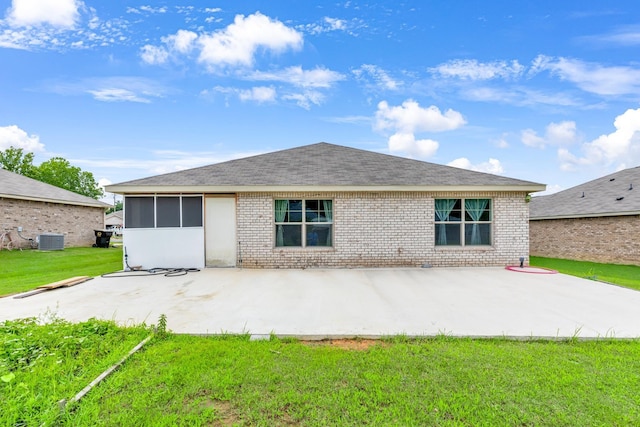  - rear view of house featuring a yard, a patio area, brick siding, central air condition unit, and roof with shingles