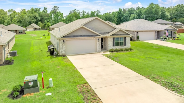  - view of front of property featuring central AC unit, an attached garage, brick siding, driveway, and a front yard