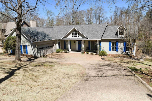  - view of front of house with driveway, a garage, a chimney, a shingled roof, and a porch