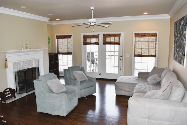  - living room with ceiling fan, dark wood-type flooring, healthy amount of natural light, crown molding, and a fireplace