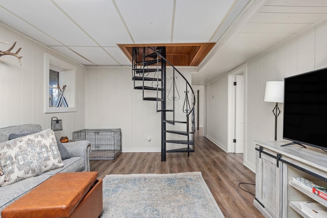 sitting room featuring wood-type flooring and a drop ceiling