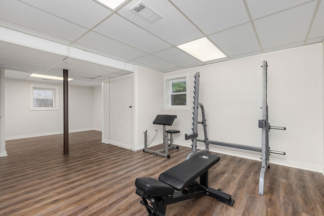 exercise area featuring a paneled ceiling and dark wood-type flooring