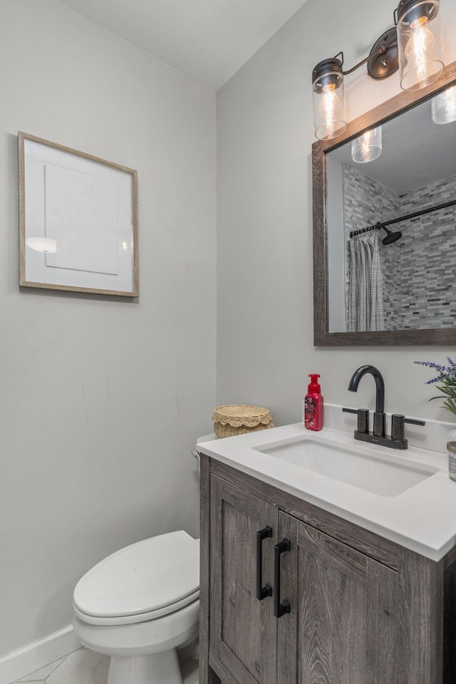 bathroom featuring curtained shower, vanity, and toilet