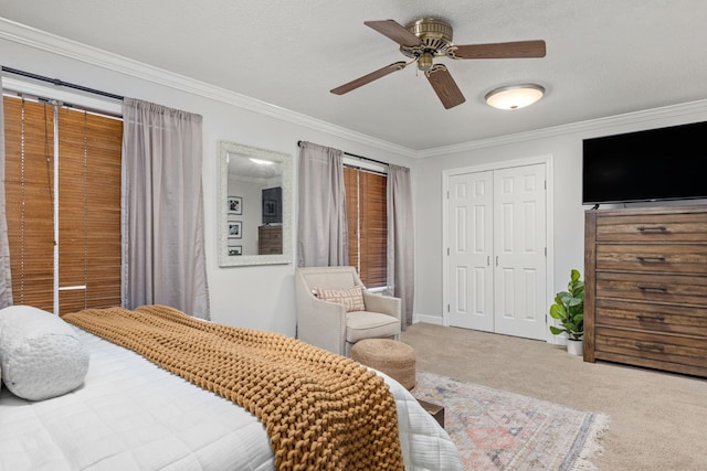 carpeted bedroom featuring ceiling fan, a closet, and ornamental molding