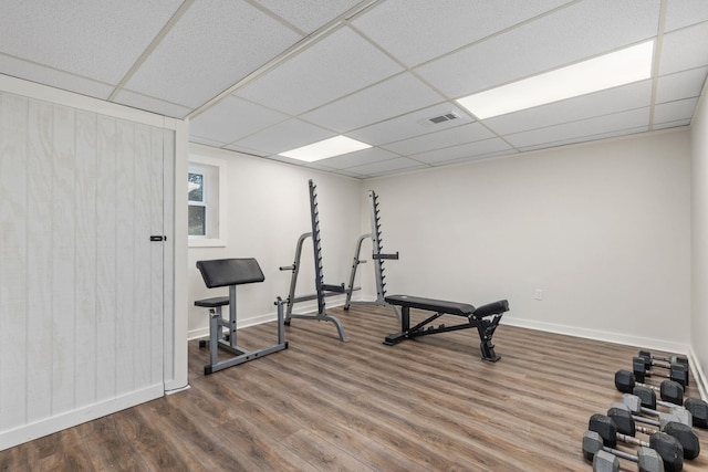 exercise area with a drop ceiling and hardwood / wood-style flooring