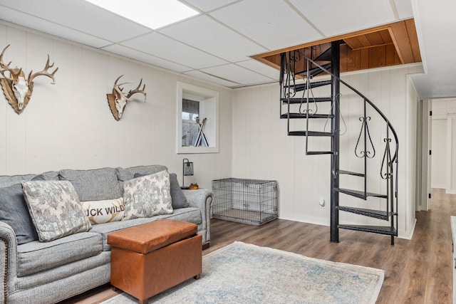 living room featuring wood-type flooring and a drop ceiling