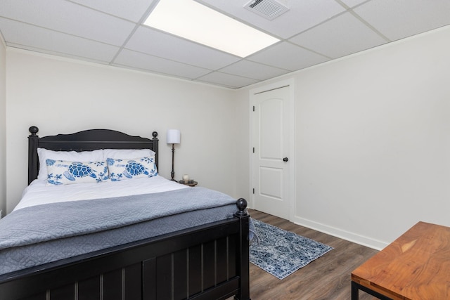 bedroom featuring a paneled ceiling and dark hardwood / wood-style flooring