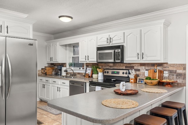 kitchen with sink, white cabinetry, light tile patterned flooring, kitchen peninsula, and stainless steel appliances