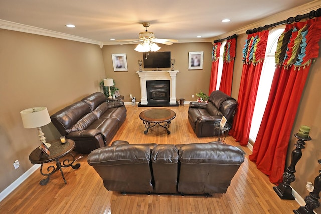 living room with ceiling fan, ornamental molding, and light hardwood / wood-style floors