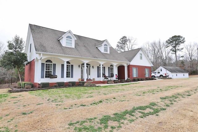 cape cod-style house with a front yard and a porch