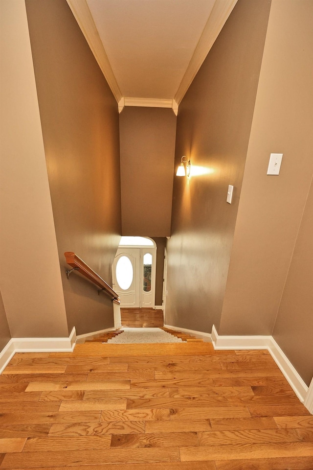 stairway featuring hardwood / wood-style flooring and crown molding