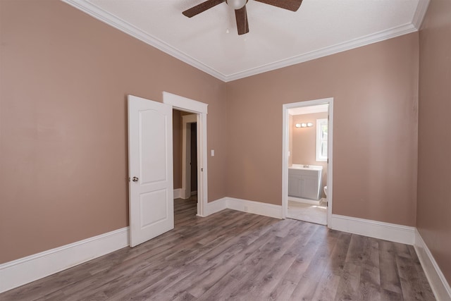 spare room with baseboards, ornamental molding, ceiling fan, and wood finished floors