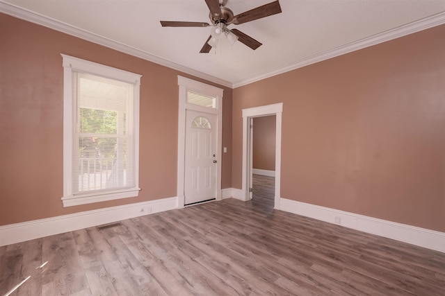 unfurnished room with baseboards, ornamental molding, ceiling fan, and wood finished floors