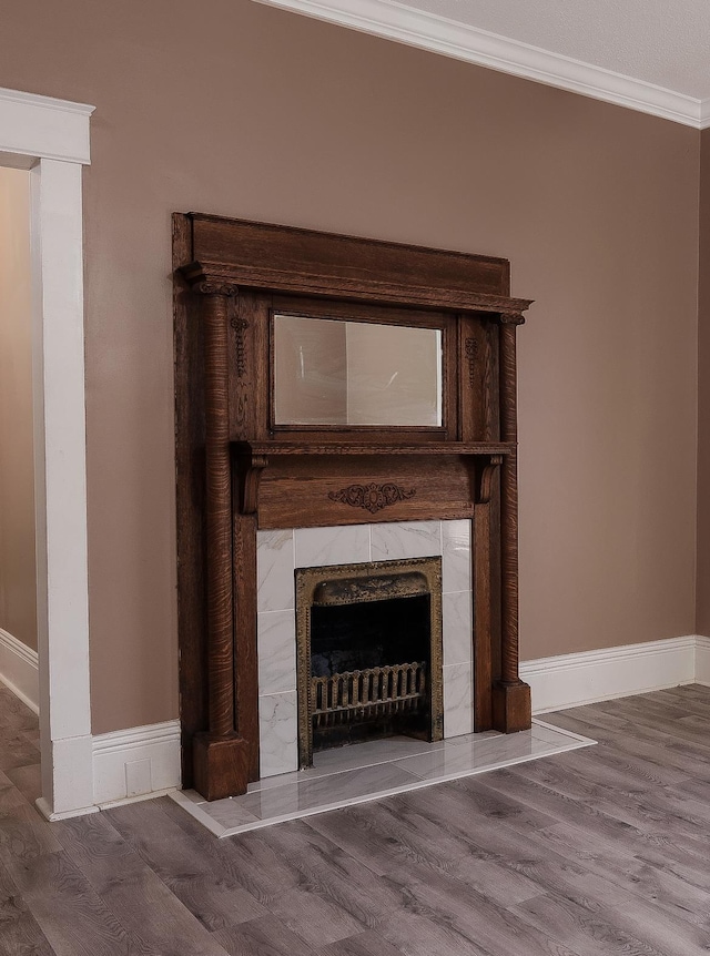 details with a high end fireplace, ornamental molding, baseboards, and wood finished floors