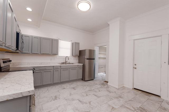 kitchen featuring crown molding, a sink, appliances with stainless steel finishes, and gray cabinetry