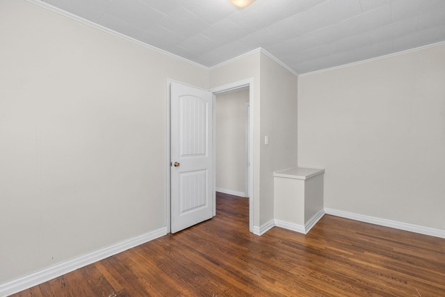 spare room with crown molding and dark hardwood / wood-style flooring