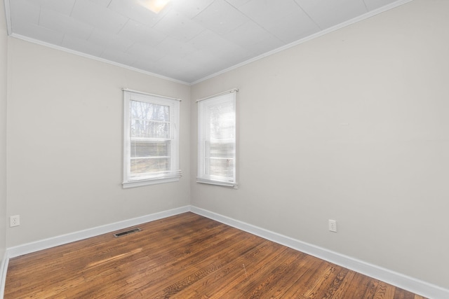 empty room featuring ornamental molding and hardwood / wood-style floors