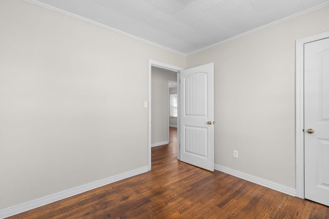 empty room featuring crown molding and dark hardwood / wood-style floors