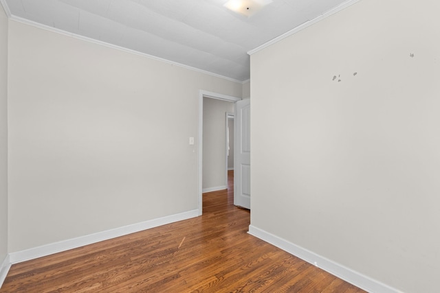 empty room with crown molding and dark hardwood / wood-style flooring