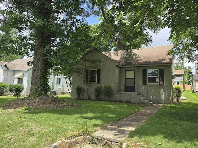  - view of front of home with stucco siding, a front yard, and a shingled roof