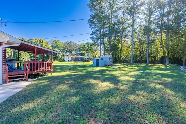 view of yard with a wooden deck and a storage shed