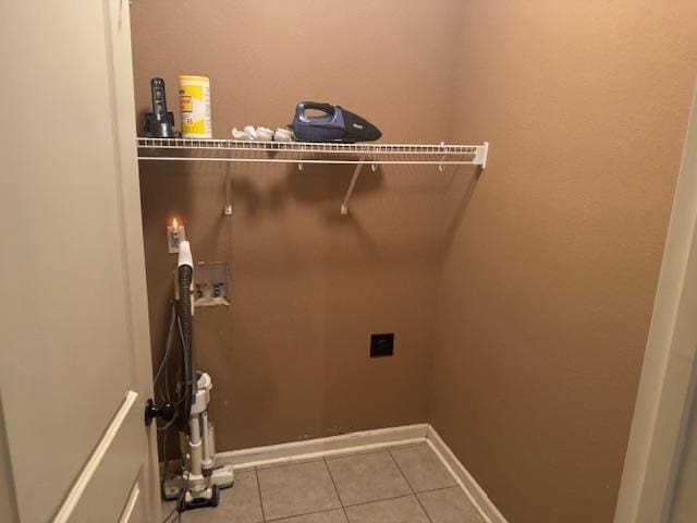 laundry area featuring laundry area, baseboards, tile patterned floors, hookup for a washing machine, and electric dryer hookup