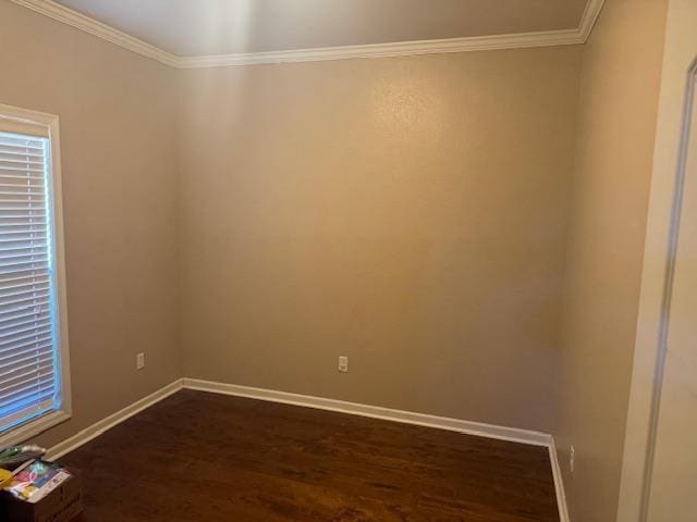 unfurnished room featuring ornamental molding, dark wood finished floors, and baseboards