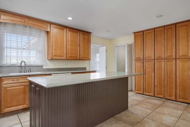 kitchen with sink, a kitchen island, and light tile patterned flooring