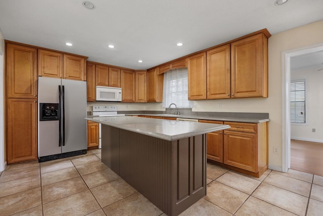 kitchen with a center island, white appliances, sink, and light tile patterned floors