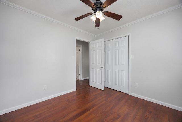 unfurnished bedroom with ornamental molding, a closet, ceiling fan, and dark wood-type flooring