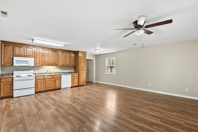 kitchen featuring ceiling fan, wood finished floors, brown cabinets, and white appliances