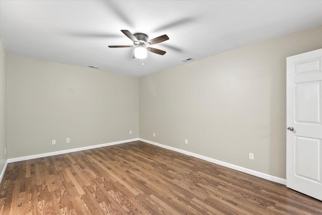 empty room featuring baseboards, visible vents, wood finished floors, and a ceiling fan