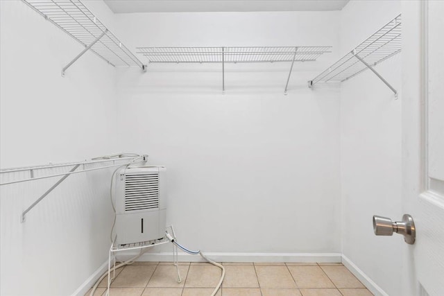 walk in closet with light tile patterned floors