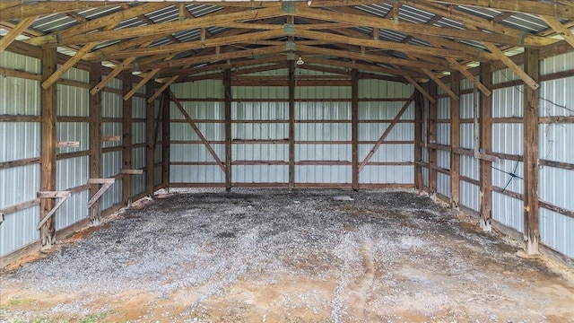 interior space featuring vaulted ceiling and metal wall