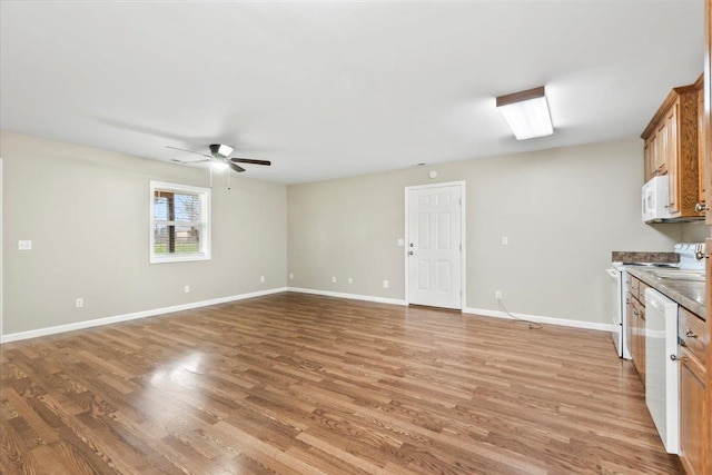 kitchen featuring baseboards, light wood-type flooring, a ceiling fan, and white appliances