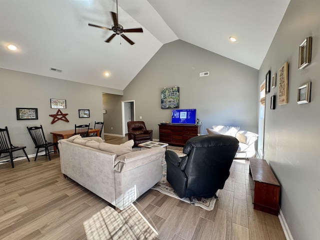 living room with high vaulted ceiling, visible vents, ceiling fan, and light wood-style flooring