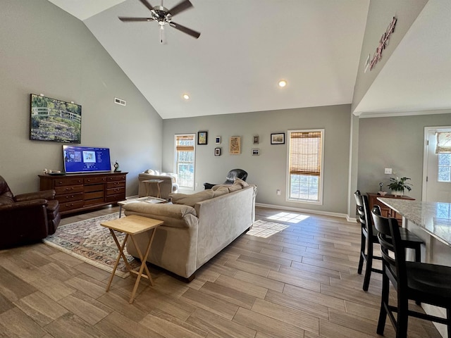 living area with wood tiled floor, visible vents, plenty of natural light, and baseboards