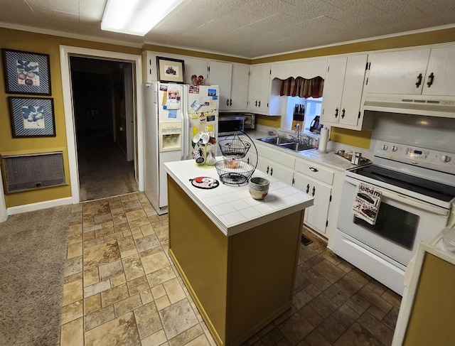  - kitchen featuring white appliances, tile countertops, under cabinet range hood, heating unit, and white cabinets