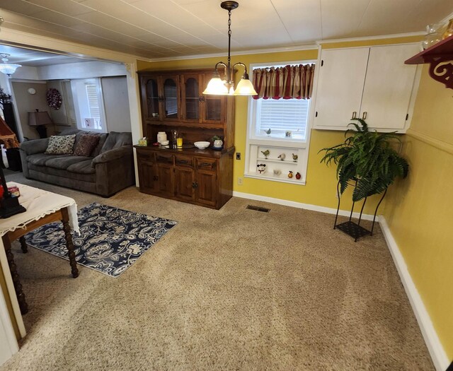  - living area featuring a chandelier, crown molding, and carpet