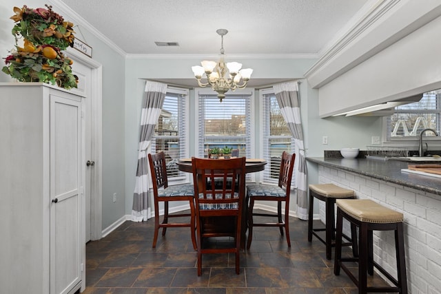 dining room featuring a textured ceiling, visible vents, baseboards, an inviting chandelier, and crown molding