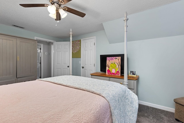 bedroom featuring baseboards, visible vents, dark carpet, and a textured ceiling