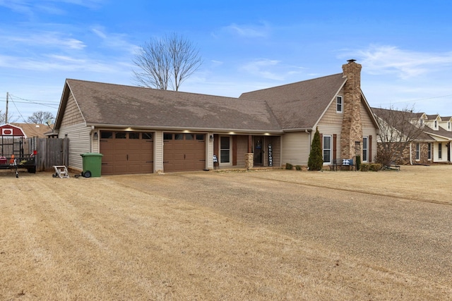 view of front of property featuring an attached garage, fence, dirt driveway, roof with shingles, and a chimney