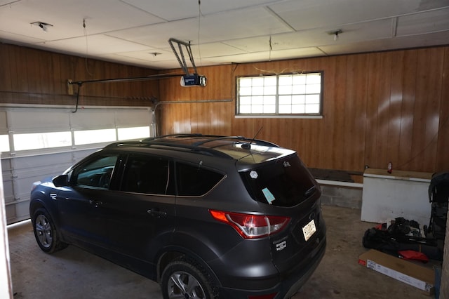 garage with a garage door opener and wooden walls