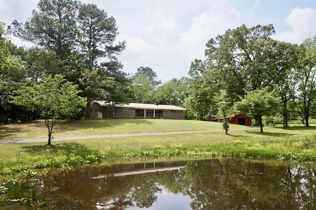 view of home's community with a water view and a yard