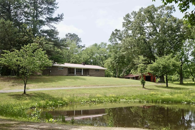 view of property's community with a water view and a yard