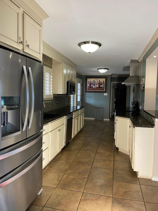 kitchen with dark tile patterned floors, extractor fan, crown molding, and appliances with stainless steel finishes