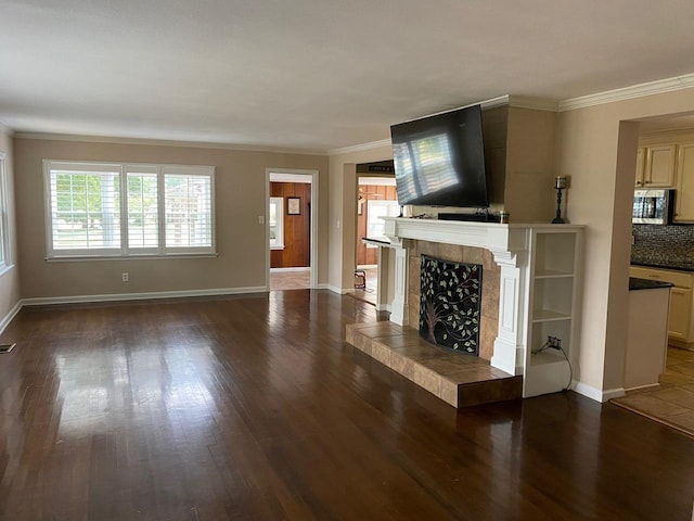 unfurnished living room featuring dark hardwood / wood-style floors, crown molding, and a fireplace