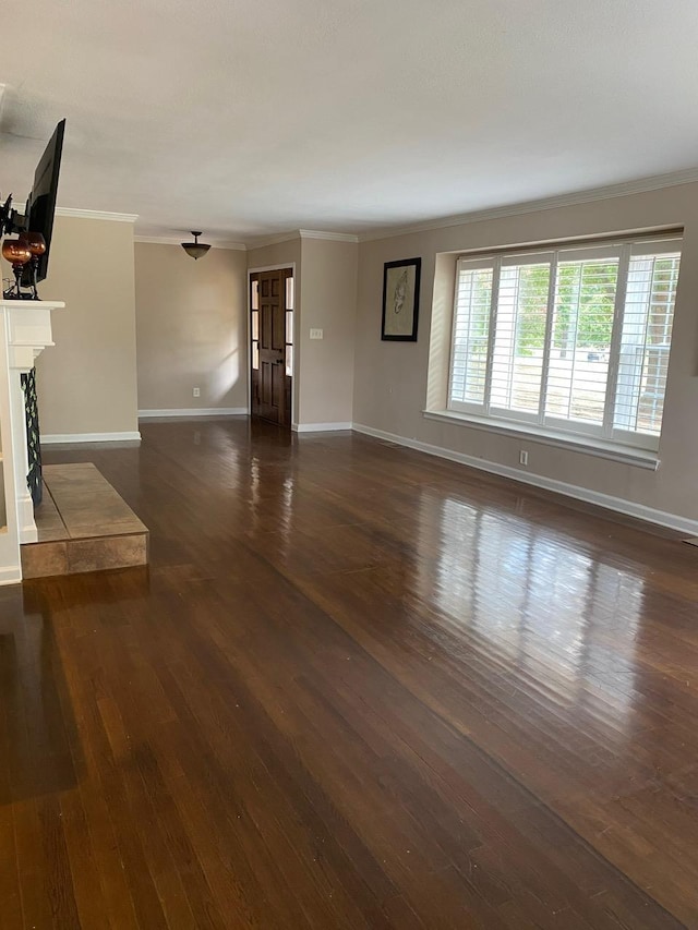 unfurnished living room featuring a tile fireplace, dark hardwood / wood-style flooring, and ornamental molding