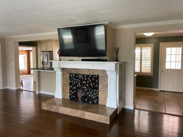 living room with a tile fireplace, dark hardwood / wood-style floors, and ornamental molding