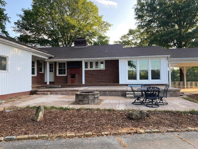 rear view of house with a fire pit, central AC unit, and a patio area